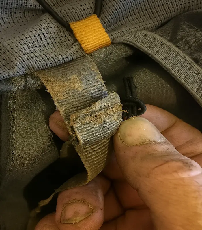 Una cinta de PP rota y quebradiza contrastada con una cinta de nailon fuerte e intacta en una mochila.